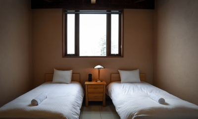 Powderhouse Bedroom with Twin Beds and Lamp and Window | Hakuba, Nagano